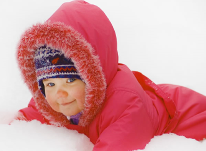 baby in red snowsuit lying in snow
