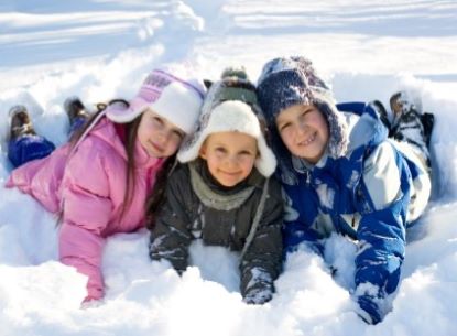 three children lying in snow